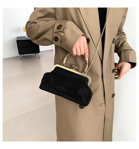 Detail of black rhinestone evening bag with gold metal frame and stylish round handle