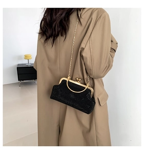 Classic black rhinestone evening bag shown as a crossbody on a stylish trench coat