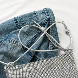 Detailansicht der glitzernden silbernen Pailletten-Handtasche mit verknotetem Riemen