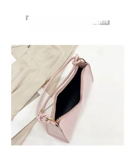 Détail du sac sous le bras rose montrant l'intérieur spacieux et les ferrures