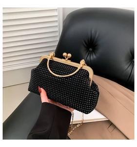 Detail of black rhinestone evening bag with gold metal frame and spherical clasp