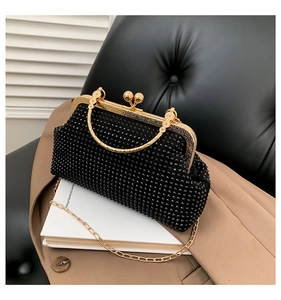 Detail showing the black rhinestone texture and vintage golden metal kiss lock closure