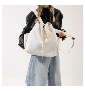 Detail of white nylon tote bag showing high-density fabric texture and fashion label