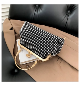 Macro shot of silver rhinestone evening clutch bag with gold round handle and metal frame
