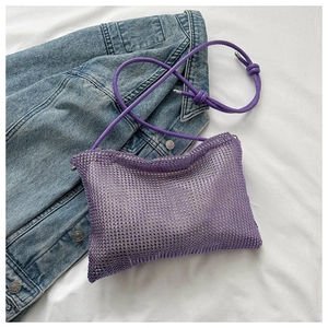 Détail du sac à bandoulière violet en maille strass sur fond de denim