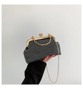 Detail of black evening clutch with sparkling silver rhinestones and gold metal handle