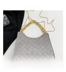 Detailansicht der grauen gesteppten Wildledertasche mit goldenem Griff und Kette