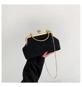 Detail of black rhinestone evening clutch with gold metal handle and vintage clasp