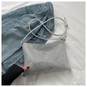 Détail du sac à main argenté avec strass brillants et fine bandoulière en cuir souple