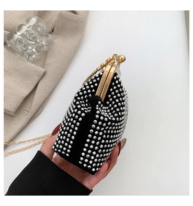 Detail of black velvet evening bag with sparkling silver rhinestones and gold chain