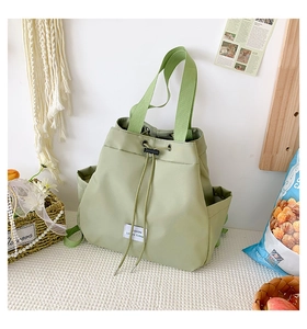 Detail of light green nylon bag with drawstring closure and fashion leisure label