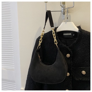 Close-up of black felt hobo bag with chunky gold chain strap and metallic zipper detail