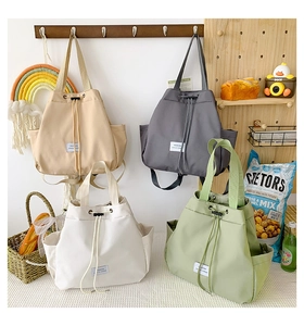 Close-up of functional drawstring nylon backpacks in beige, gray, white and light green colors