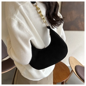 Detail of black suede crescent bag with textured matte finish and gold chunky chain strap