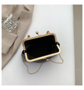 Detail view of sparkly evening bag featuring silver rhinestones and gold clasp closure
