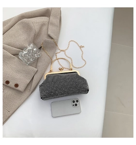 Detailed top view of a black evening clutch with silver rhinestones and gold handle