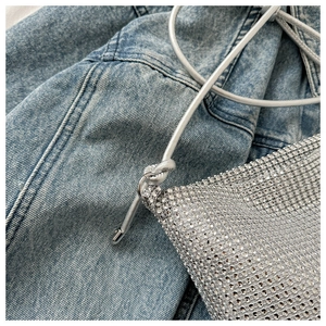 Gros plan d'un sac en résille à strass argentés avec lanière en cuir élégante