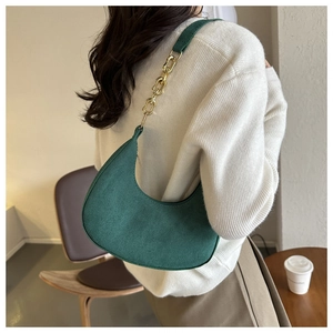 Detail of vintage dark green felt shoulder bag with golden metal chain and zipper