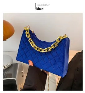 Detail der blauen Samt-Achseltasche mit Rautensteppung und klobiger goldener Kette