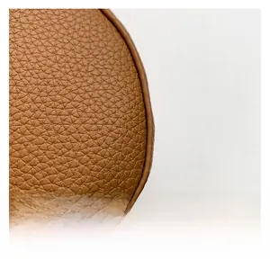 Macro shot of high-quality brown lychee textured leather showing detailed grain and stitching