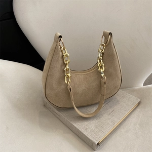 Chic beige felt underarm bag with gold chain strap on a minimalist cream background