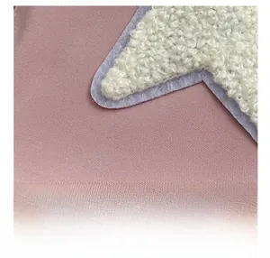 Detailed macro view of the premium fabric texture and plush star embroidery on the bag