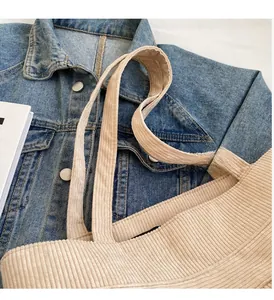 Close-up of wide corduroy straps and texture on the beige tote bag handle