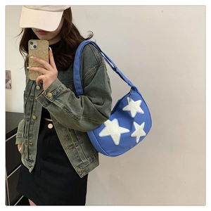 Blue nylon hobo bag with white plush stars shown in a mirror selfie style