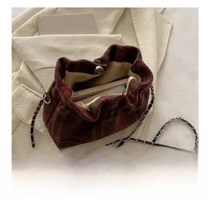 Détail du sac seau à carreaux vintage avec bandoulière chaîne montrant la capacité
