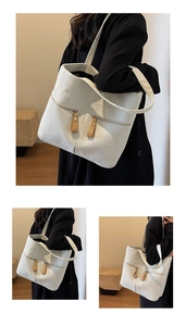 Detail of off-white corduroy tote bag with dual front zippers and brown leather pulls