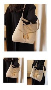 Detail of off-white corduroy tote bag showing vertical texture and dual metal zippers