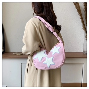 Pink crescent nylon bag detail showing white star patches and adjustable wide strap
