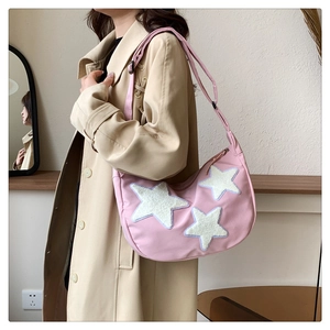 Detail of pink crescent bag showing white plush stars with light blue stitching