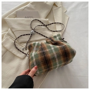 Détail du sac bandoulière en laine à carreaux avec boule métallique argentée sur chaîne
