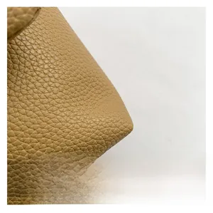 Gros plan détaillé montrant la texture du cuir à motif litchi de ce sac à main