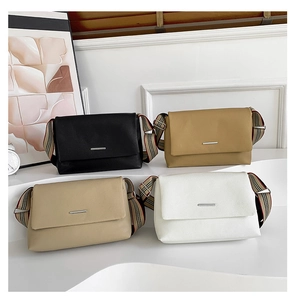 Détail de sacs à bandoulière minimalistes en cuir en quatre couleurs avec sangles tartan