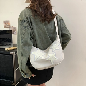 Minimalist white crescent nylon crossbody bag with plush star patches and wide shoulder strap