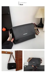 Détail du sac bandoulière noir en cuir grainé avec large sangle en tissu tricolore