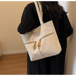 Detail of off-white corduroy tote bag with functional zipper pocket and leather puller