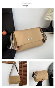 Détail du sac bandoulière marron avec barre argentée et large bandoulière rayée