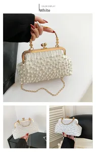 Détail de pochette de soirée en satin blanc ornée de perles et fermoir en métal doré