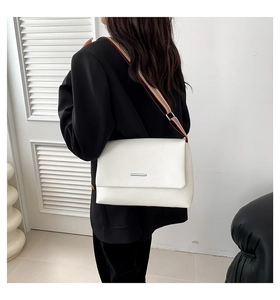 Détail du sac à main blanc en cuir grainé avec boucle en métal et bandoulière rayée