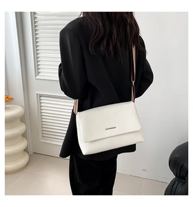 Détail du sac bandoulière blanc en cuir grainé avec une bandoulière tissée rayée