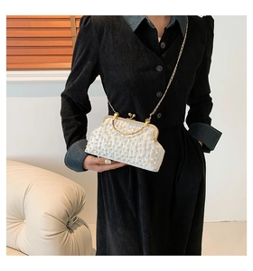Détail du sac de soirée à perles blanches avec fermoir vintage doré et chaîne