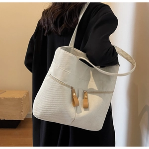 Detailed shot of corduroy tote bag featuring dual front zipper pockets and ribbed texture