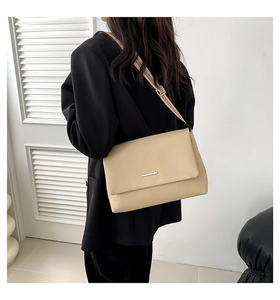 Sac bandoulière beige en cuir texturé avec bandoulière tissée à rayures en gros plan