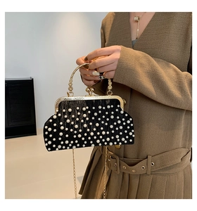 Détail du sac de soirée vintage avec perles blanches et poignée dorée gravée