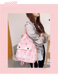 Détail d'un sac à dos rose clair avec cordons, motifs de lapins mignons et fleurs de fille