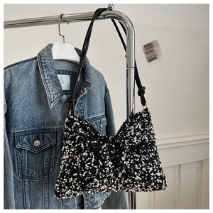 Retro schoudertas met pailletten en zwart lederen riem over denim jasje