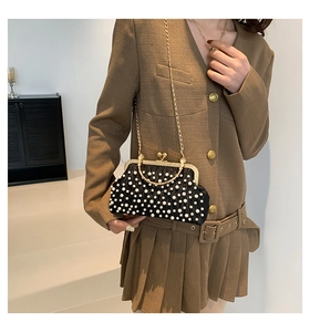 Détail du sac de soirée noir perlé avec fermoir cœur et chaîne dorée fine